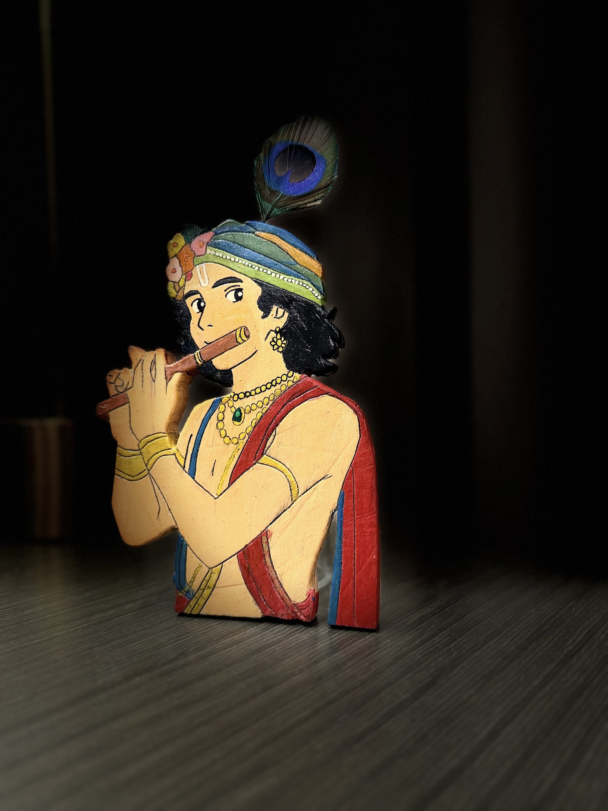 Side profile view of handcrafted wooden Krishna figurine showing carved depth and painted details