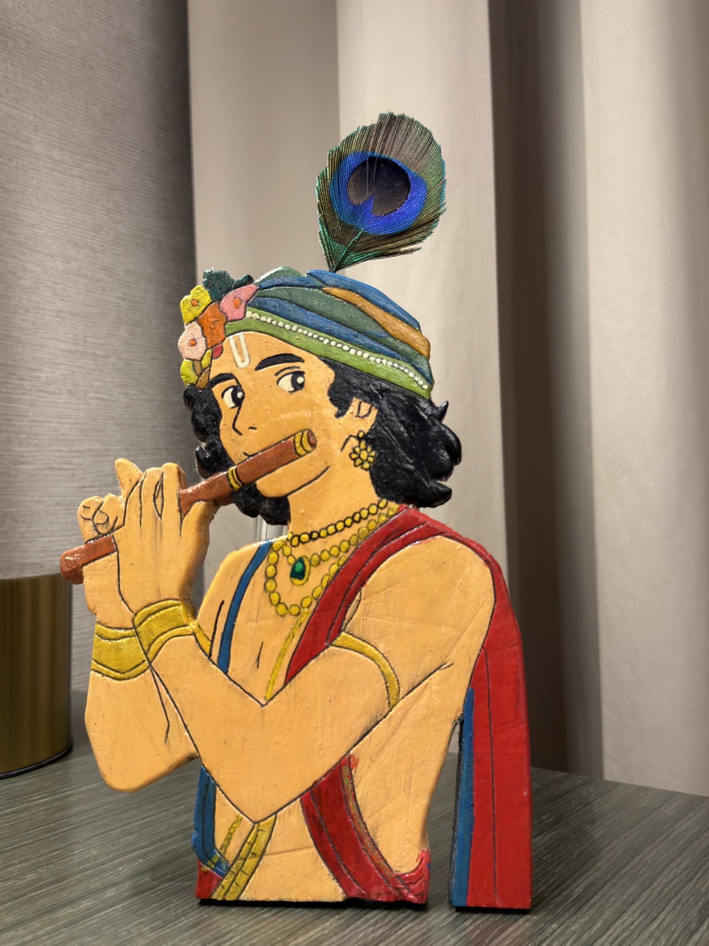 Handcrafted wooden Krishna figurine with vibrant red, blue and gold hand-painted details