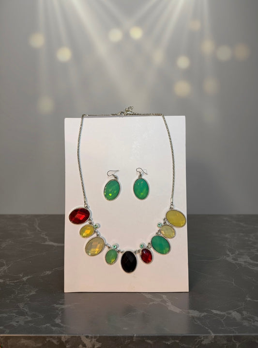 Cartagena multicolor statement necklace and earrings on wet black volcanic rock with jade green and garnet stones catching light