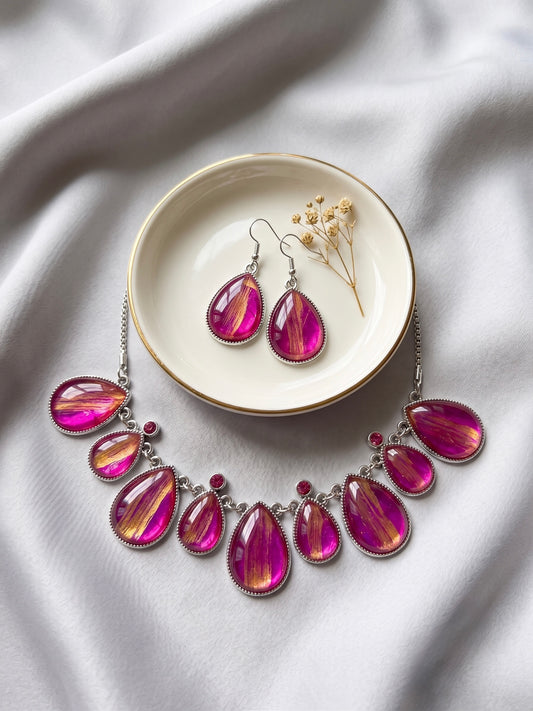 ARTIGAO Kyoto pink and gold statement necklace and earring set on white satin with earrings in ceramic dish and dried flowers