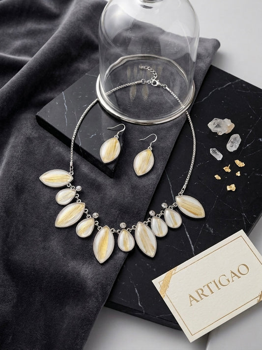 ARTIGAO Mykonos white and gold statement necklace and earring set on black marble with glass dome and brand card
